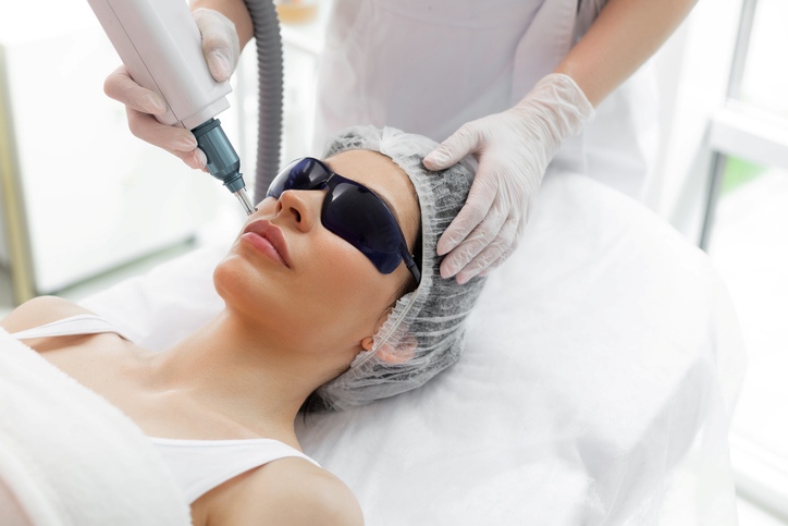 Laser skin treatment on a woman's face with protective goggles in Fort Collins & Loveland, CO